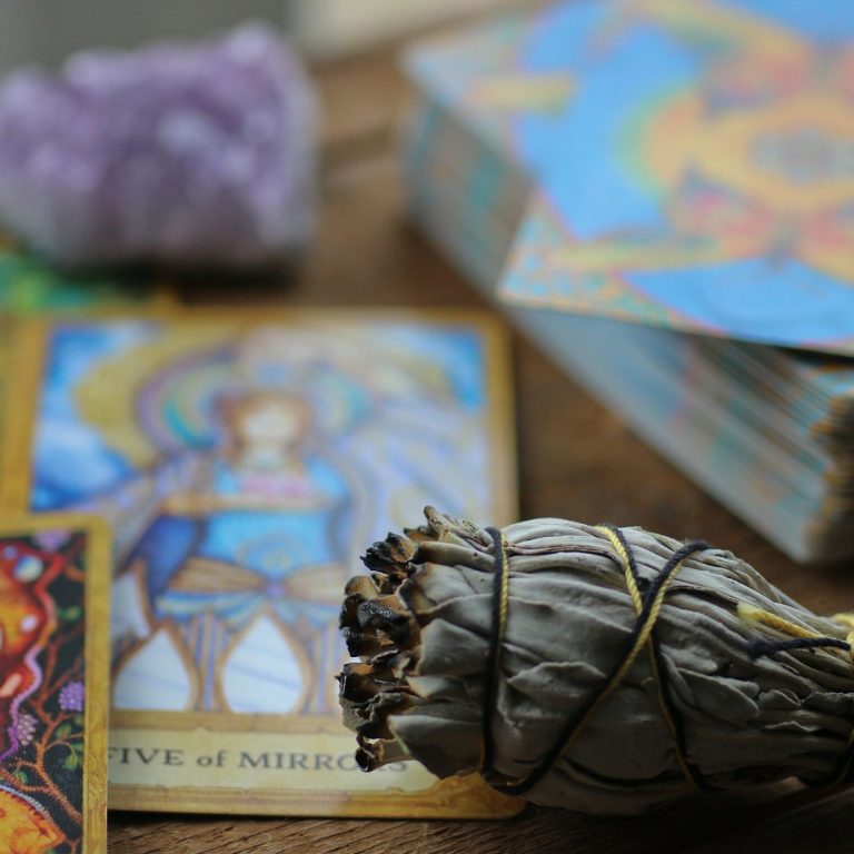 Sage Bundle and Tarot Cards A tarot reading with tarot cards, sage for cleansing energy, and amethyst crystals, symbolizing spiritual practice and divination.